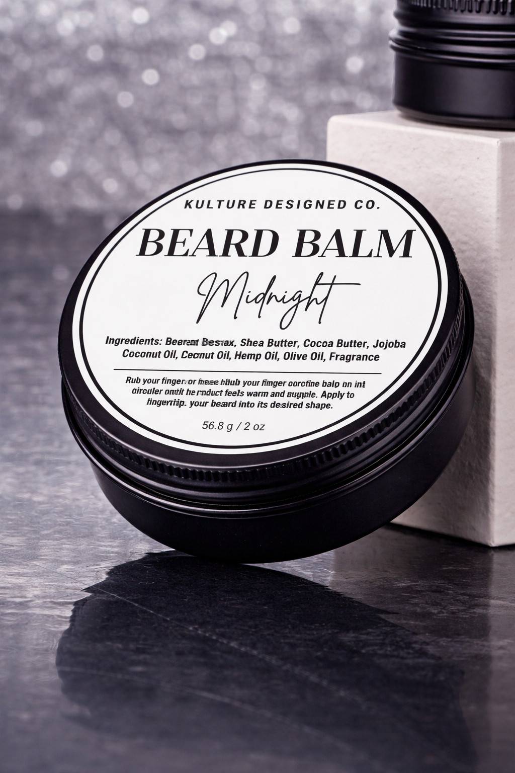 Beard balm container labeled 'Kulture Designed Co. Beard Balm Midnight' on a dark surface.
