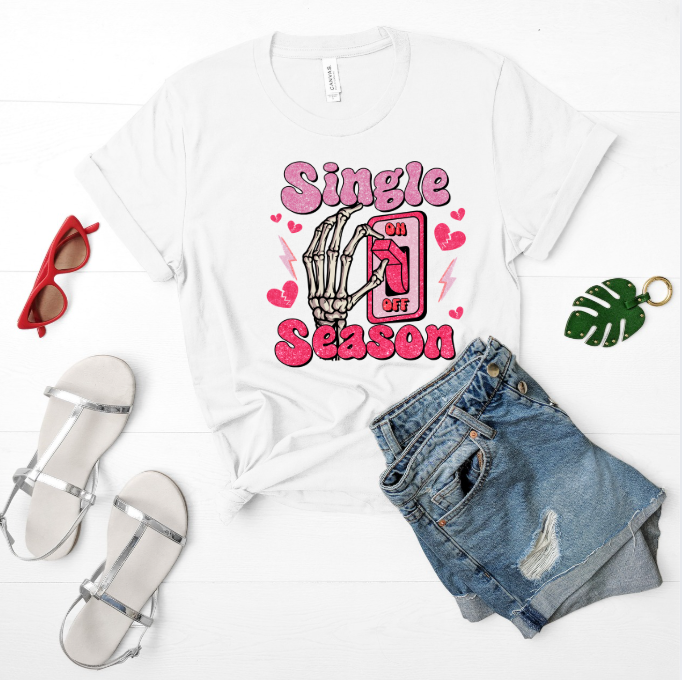 White t-shirt with 'Single Season' design, sunglasses, sandals, and shorts on a white background