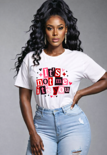 Woman wearing a white t-shirt with a red and black graphic and text, standing against a gray background.