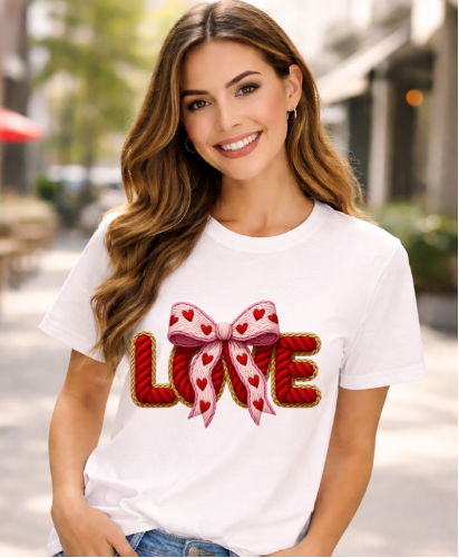 Woman wearing a white t-shirt with a decorative 'LOVE' design outdoors.